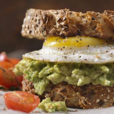 Creamy Avocado Sandwich with a Fried Egg and Tomatoes